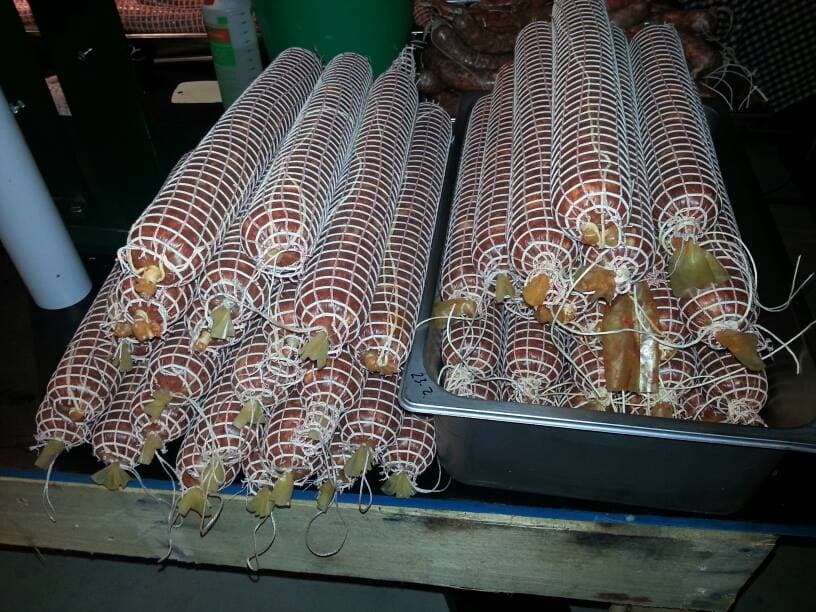 Cooked sausages plated on a board.